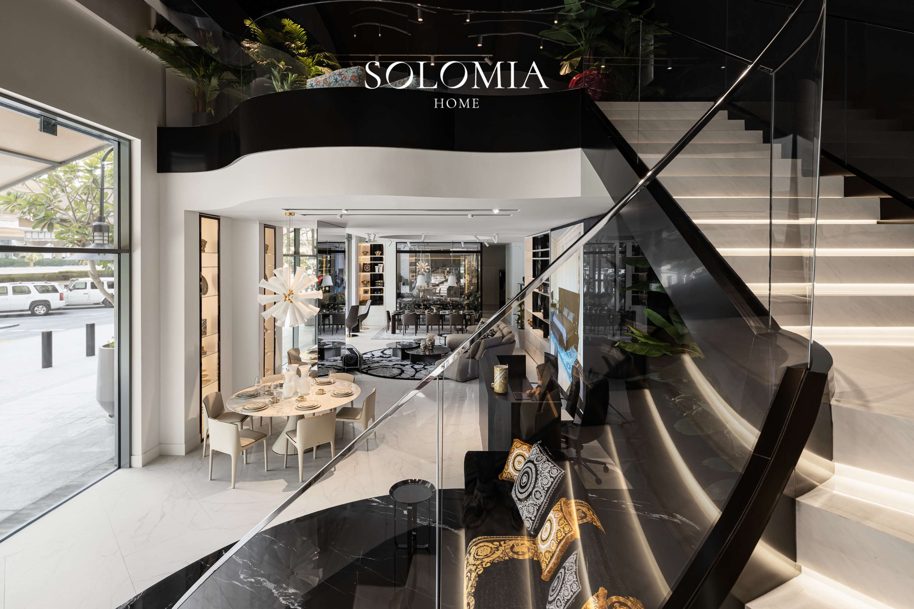 Showroom with curved staircase and dining table, Versace Home showroom Dubai Mall — commercial interior design by Solomia Design